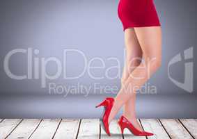 Sexy woman's legs with red skirt and shoes in front of grey background