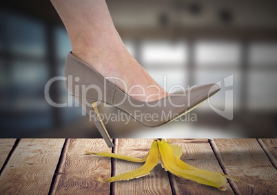 Woman's foot about to step on banana peel and slip mistakenly on wood