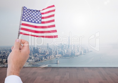 Hand holding American flag  in front of city