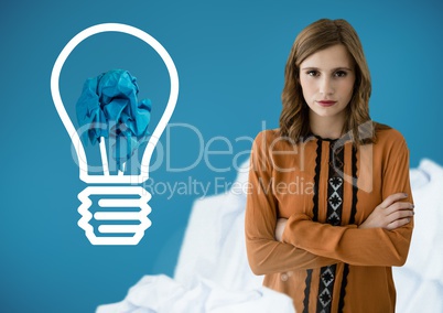 Woman standing next to light bulb with crumpled paper ball