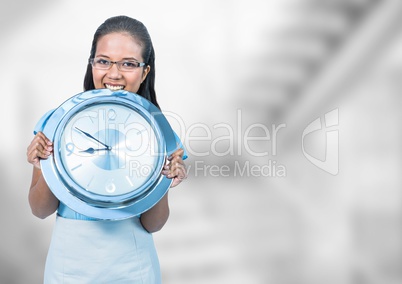 Woman holding clock in front of staircase