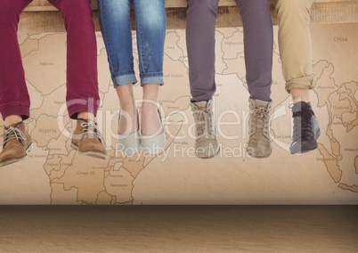 Group of people's legs sitting on wooden plank in front of world map