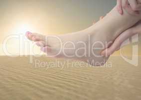 Hands holding foot in desert
