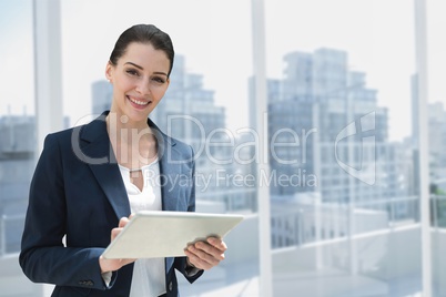 Happy business woman using a tablet against city background