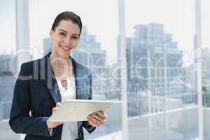 Happy business woman using a tablet against city background