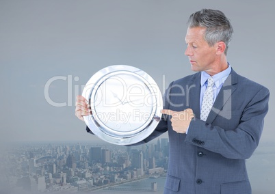 man holding clock in front of city