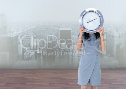 Woman holding clock in front of city