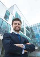 Happy business man standing against building background