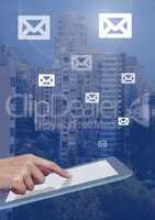 Holding tablet and email icons over city