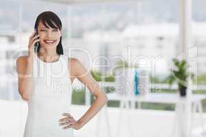 Happy business woman talking on the phone against office background