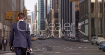 Business man holding a suitcase against city background