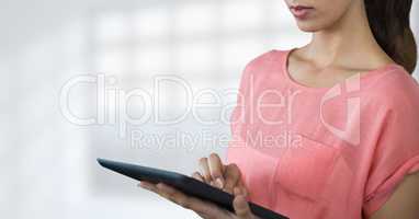 Business woman using a tablet against white blurred background