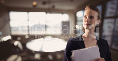 Business woman holding files against office background