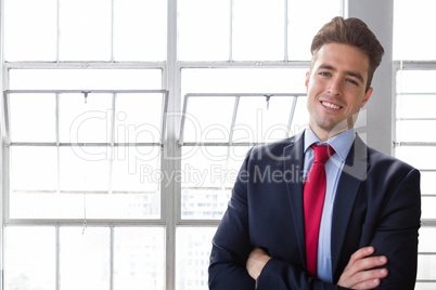 Happy business man standing against building background