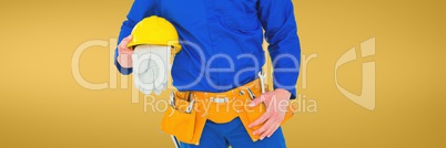 Plumber man holding globes and a helmet against yellow background
