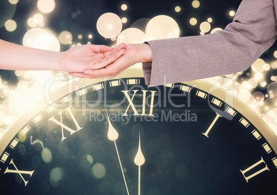 Couple's hands holding over magical time clock with sparkles