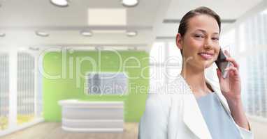 Happy business woman talking on the phone against office background