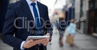 Business man holding a notebook against street background