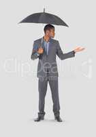 Full body portrait of man holding umbrella standing with grey background