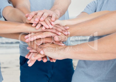 Lots of hands together with sea background