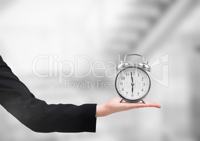 Arm holding clock with bright blurred background