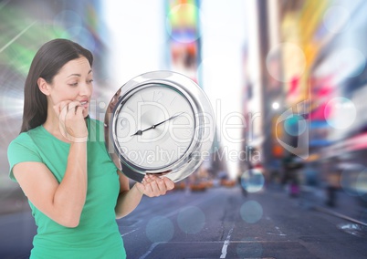 Woman holding clock in front of city rush