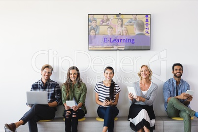 People sitting under a TV with e-learning information in the screen