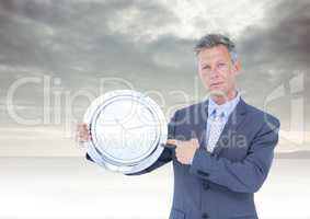 man holding clock in front of cloudy sky
