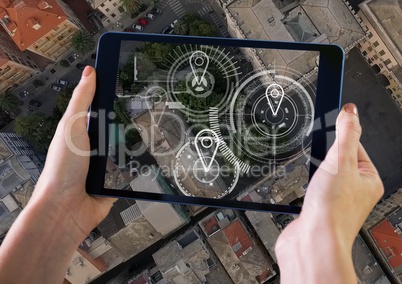 Holding tablet and City aerial view with marker location pointers