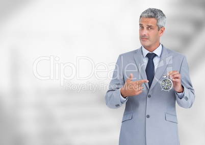 man holding clock in front of bright blurred background