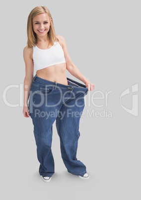 Full body portrait of slim fit woman standing and wearing over sized clothes with grey background