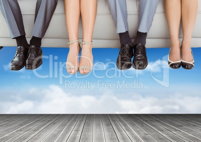 Peoples legs and feet hanging off floating couch over sky