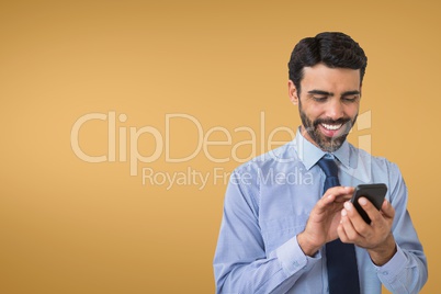 Happy business man using the phone against orange background