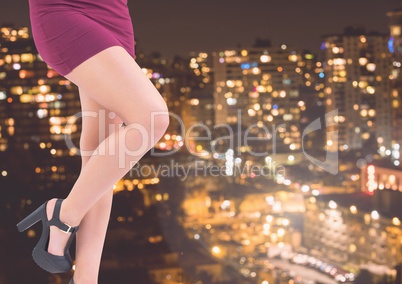 Sexy woman's legs in front of night city
