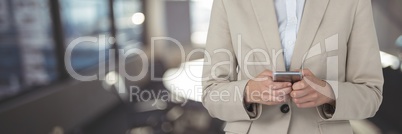 Business woman using a phone against office background