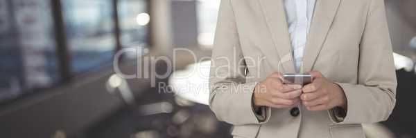 Business woman using a phone against office background