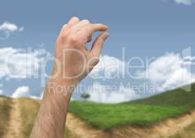 Hand touching sky in landscape