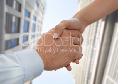 Business people shaking hands against city background