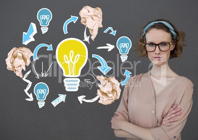 Woman standing next to light bulb with crumpled paper balls in front of blackboard