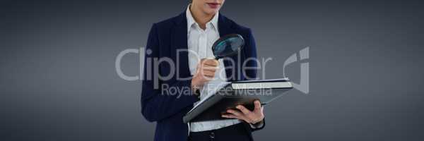Woman with a magnifying glass against grey background as looking for an insurance concept
