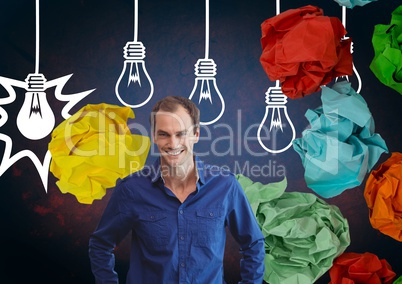 Man standing next to light bulbs with colorful crumpled paper balls