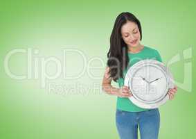 Woman holding clock in front of green background