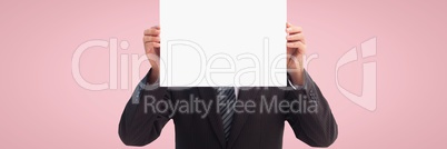 Business man holding a blank card against pink background