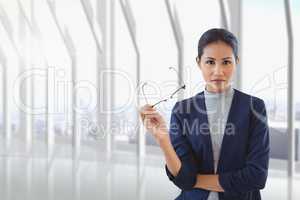 Business woman holding her glasses against building background