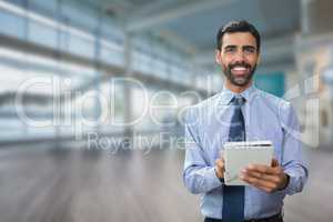 Happy business man using a tablet against office background