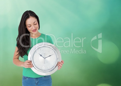 Woman holding clock in front of green sparkles bokeh light