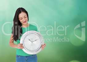 Woman holding clock in front of green sparkles bokeh light