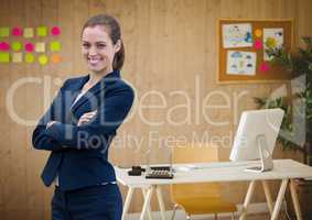 Happy business woman standing against office background