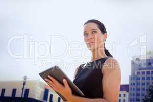 Business woman using a tablet against city background