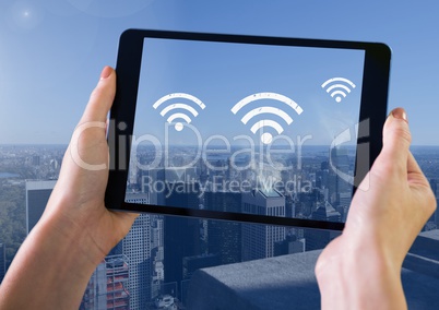 Holding tablet and City with icons of wifi